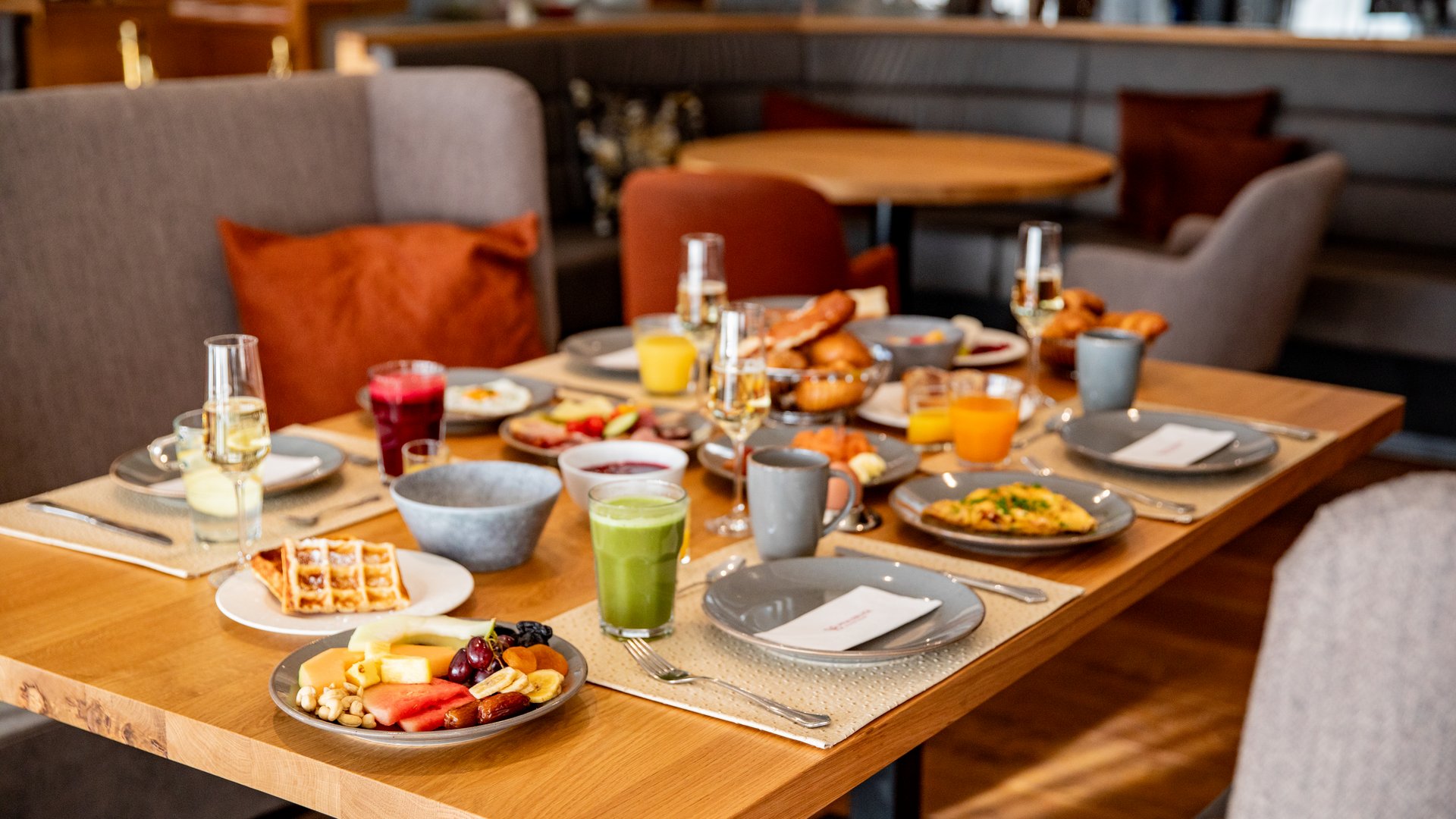 Frühstückstisch mit verschiedenen Getränken und Speisen in gemütlichem Restaurant