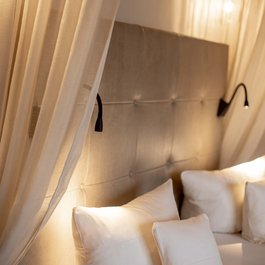 Gemütliches Schlafzimmer mit gepolstertem Kopfteil und weißen Kissen