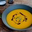 Kürbissuppe mit Kürbiskernen und Balsamico-Glasur in schwarzer Schüssel