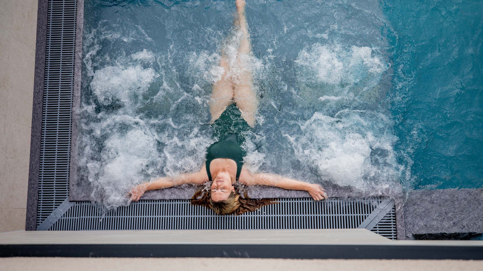 Femme se détend dans un jacuzzi avec de l'eau bouillonnante