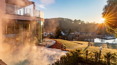 Vapeur près d'un bâtiment moderne au coucher du soleil